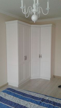 an empty bedroom with white closets and blue striped bedspread on the floor