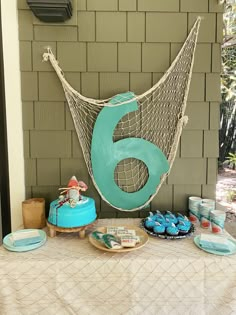 a table topped with cakes and cupcakes next to a hammock net