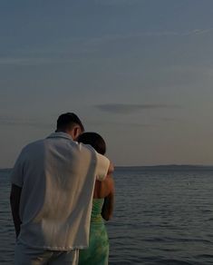 a man and woman looking out at the ocean