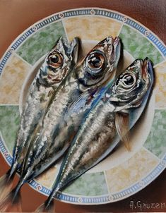 three fish sitting on top of a white plate next to a green and yellow tile wall