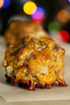 a piece of food sitting on top of a piece of paper with lights in the background