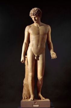 a statue of a naked man holding a dog