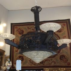 a chandelier hanging from the ceiling in a room with rugs on the wall