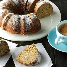 a bundt cake sitting on top of a white plate next to a cup of coffee