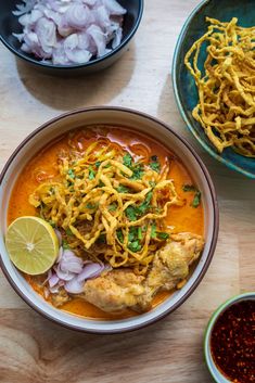 three bowls of food on a wooden table