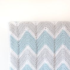 a crocheted blanket sitting on top of a white wall