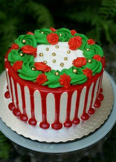 a decorated cake sitting on top of a white and red platter covered in frosting