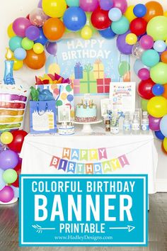 a colorful birthday party with balloons, cake and banner on the table in front of it