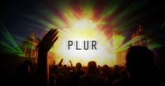 the words plur are in front of a stage full of people with their hands up