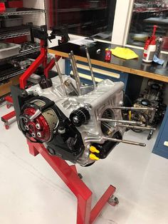 a car engine being worked on in a garage with tools and other items around it