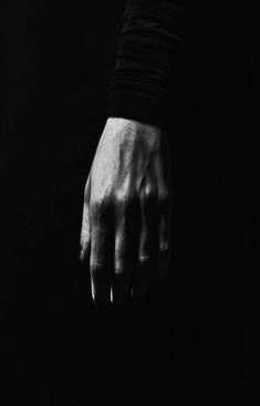 a person's hand in the dark with their fingers extended to one side and on the other