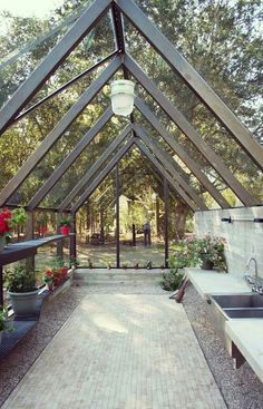 the inside of a building that has some plants in it and flowers on the outside