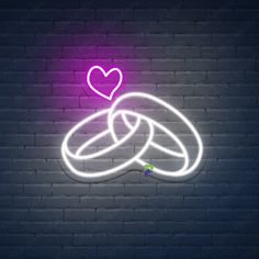 a neon sign with two intertwined rings and a heart in the middle on a brick wall