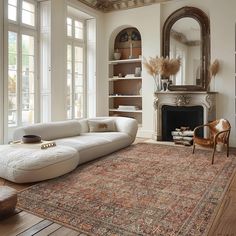 a living room with a large rug and fireplace