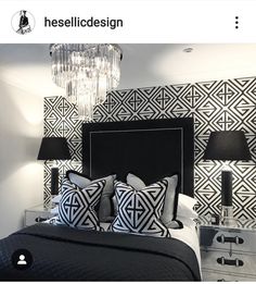 a black and white bedroom with chandelier on the headboard, two nightstands