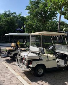 two golf carts parked next to each other