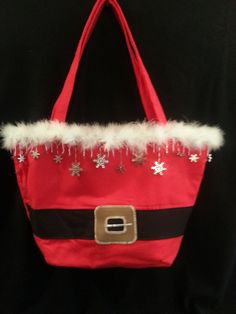 Handmade "Santa Motif" Tote-type purse, all made and lined with Red soft durable fabric.   At  +11" H  X  17"  Top, down to 10" Bottom, this bag is large enough to help with your Holiday shopping. 2--10"  X  1", reinforced handles Inside pocket,lined Faux Fur Trim Faux Leather-Stitched Buckle w/ prong stitched in silver thread, all on top of Black canvas-type fabric belt Hand-Beaded, w/ Snowflakes/Iridescent Bead Mix,along top edge of purse Wipe clean All Handmade in the USA Great Gift Idea ! Red Christmas Gift Bags, Red Christmas Bag For Everyday Use, Red Bag For Everyday Use And Christmas, Red Christmas Bags For Everyday Use, Christmas Purse, Christmas Gift Bags, Christmas Sewing, Holiday Shopping, Fabric Belt