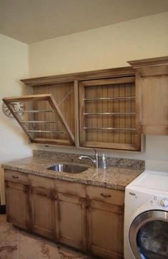 an image of a kitchen with cabinets and a washer dryer in the middle