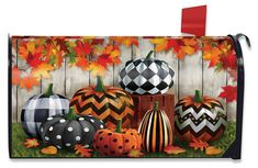 a mailbox cover with pumpkins and leaves painted on the front, along with fall foliage