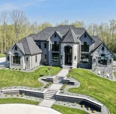 this is an aerial view of a large house in the country side with stone and brick accents