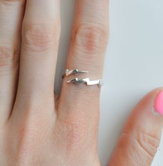 "Get ready to add a touch of electricity to your jewelry collection with our sterling silver lightning bolt ring! This unique and versatile ring features a stylish zigzag design that can be worn on your index or pointer finger, or even as a trendy thumb ring. Crafted with high-quality materials, our wrap around lightning ring is perfect for those who want to make a statement. Rings are sold in sizes 5 6 7 8 9 10 PRODUCT DETAILS * Ring is solid 925 sterling silver * Width of band measures 2.5mm * Bolt Promise Rings, Bolt Rings, Nickel-free Minimalist Sterling Silver Rings, Sterling Silver Triangle Rings For Gifts, Lightning Ring, Lightning Bolt Ring, Zigzag Design, Silver Rings Simple, Detailed Ring