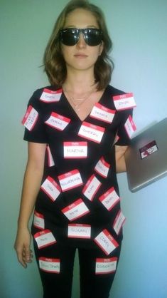 a woman wearing sunglasses and a black shirt with red tags on it, holding a laptop