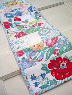 a close up of a flowered table runner on a door mat with white trim