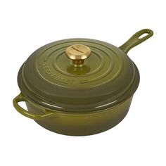 a green casserole with a gold lid