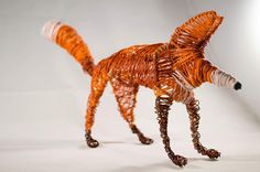 an orange dog made out of wire on a white background