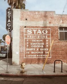 a brick building with street signs on the side and a fire hydrant next to it