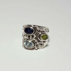 Ornate Sterling Silver Ring With Swirl And Bead Designs Around Genuine Peridot, Blue Topaz, And Iolite Stones. The Band Tappers From 18 Mm To 8 Mm. Funky Jewelry Rings, Funky Rings, Iolite Stone, Cabochon Ring, Pretty Jewelry, Funky Jewelry, Class Ideas, Funky Nails, Multi Stone Ring