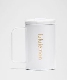 a white coffee mug with gold lettering on the front and inside that says inner city