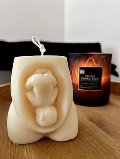 a candle that is on top of a table next to a box with an object in it