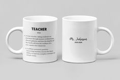 two white coffee mugs sitting side by side on a gray background with the words teacher written in black