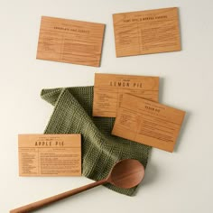 wooden business cards and spoon sitting on top of a green napkin next to each other