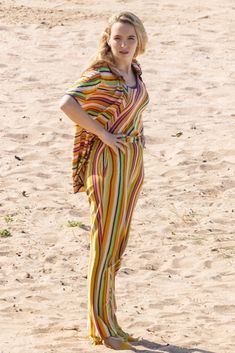 a woman standing on top of a sandy beach