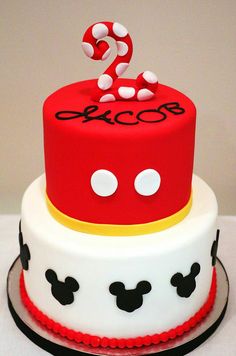 a red and white cake with mickey mouse decorations