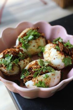 some food is in a pink bowl on a table