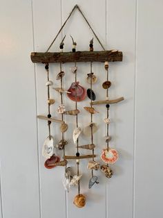 a wind chime hanging from the side of a wall with seashells on it