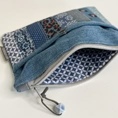 the zippered pouch is made from denim and has an animal print pattern on it