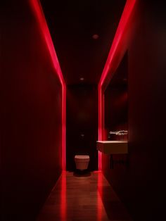 a long hallway with red lights and a sink