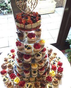 a tower of cupcakes and pastries on a table