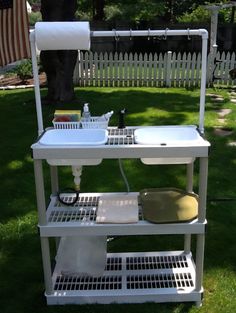 a white sink sitting on top of a metal shelf next to a green field with an american flag in the background