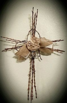 a cross made out of twigs and burlock tied with twine on the wall