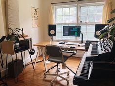 a room with a keyboard, piano and other musical equipment