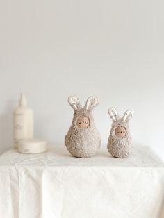 two stuffed animals sitting on top of a white table