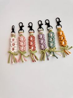 six crocheted key chains tied together in different colors and sizes with black handles