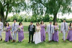 a group of people standing next to each other on top of a lush green field