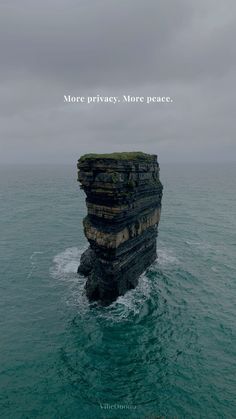 a rock outcropping into the ocean with a quote above it that reads more privacy, more peace