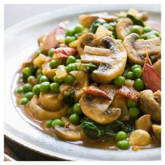 a white plate topped with peas and mushrooms